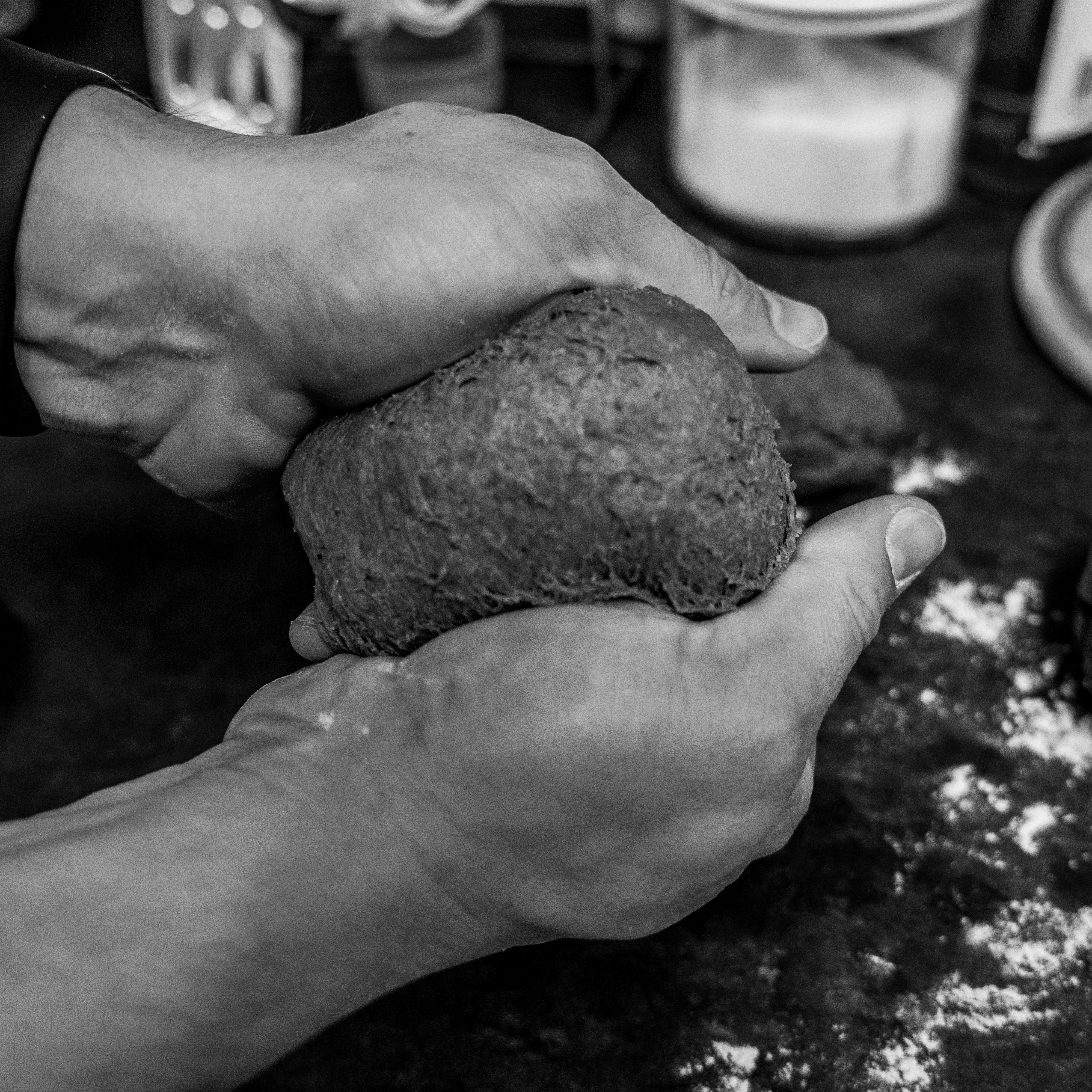 grayscale photo of person holding stone